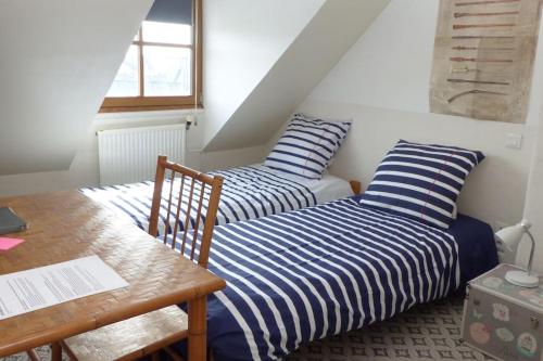2 Betten in einem Zimmer mit einem Schreibtisch und einem Tisch in der Unterkunft Exceptionnel Appartement à Vannes, vue sur les remparts in Vannes
