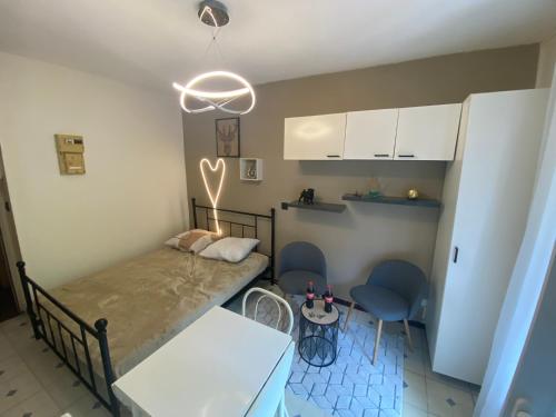 une chambre avec un lit, une table et des chaises dans l'établissement Joli T1 Amélie-les-Bains-Palalda, à Amélie-les-Bains-Palalda