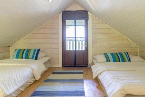 a attic room with two beds and a door at Traditional Seaside Cottage 