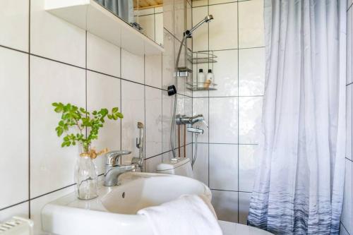 y baño blanco con lavabo y ducha. en Traditional Seaside Cottage 