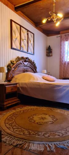 a bedroom with a large bed with a wooden headboard at Fleur de vanille in Le Tampon