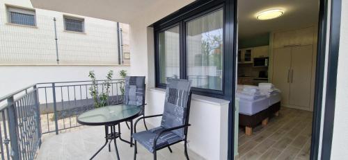 a balcony with a table and chairs and a kitchen at Anton Apartmanház in Balatonfüred