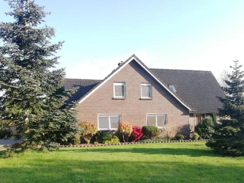 una casa con un césped verde delante de ella en Ferienwohnung im Fehnland 35667, en Uplengen