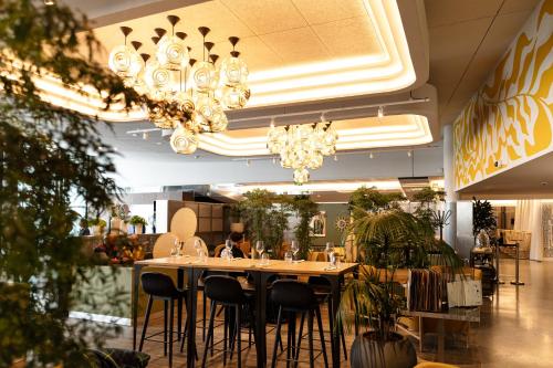 a restaurant with a table and chairs and chandeliers at Pullman Paris Centre - Bercy in Paris