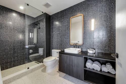 a bathroom with a toilet and a sink and a mirror at 21st FL 2BD Condo-Rainey St-Best views in Austin
