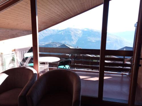 a room with chairs and a view of mountains at Apartment in Anzère in Anzère