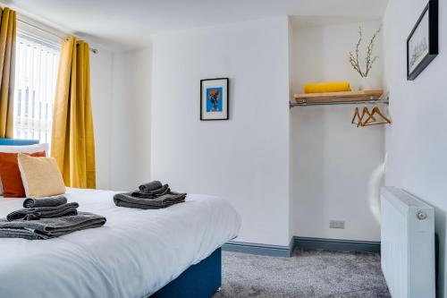 - une chambre avec un lit et des serviettes dans l'établissement Cosy 3 bedroom house near Anfield Stadium, à Liverpool