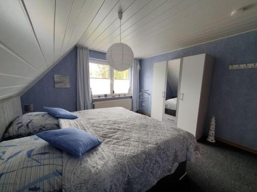 1 dormitorio con 1 cama grande y paredes azules en Ferienwohnung im Fehnland 35667, en Uplengen