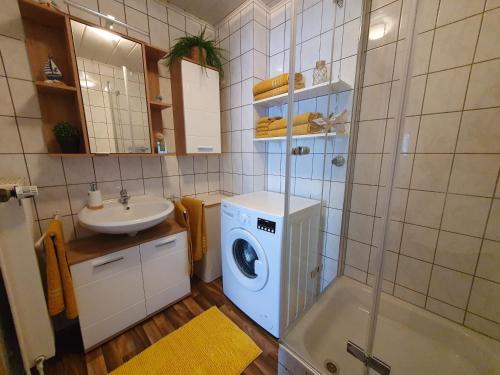 a bathroom with a washing machine and a sink at Ferienwohnung im Fehnland 35667 in Uplengen