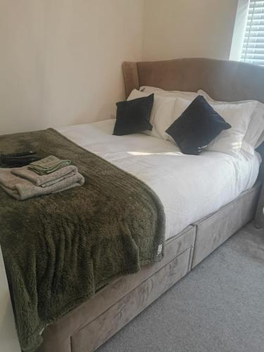een bed met een deken en kussens erop bij Burton House 