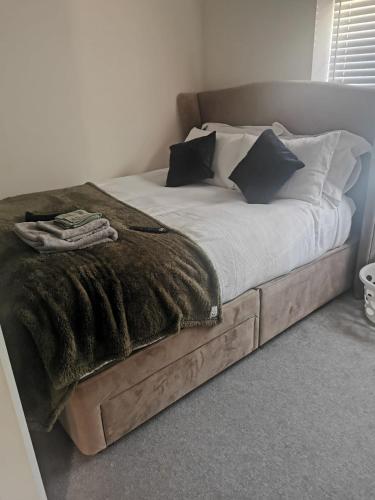 a bed with a wooden frame with a blanket on it at Burton House 