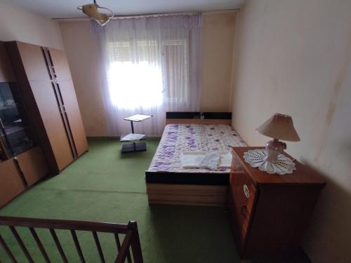 a bedroom with a bed and a table and a window at Sremac in Kupinovo