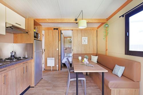 una cocina y comedor con una mesa en una casa pequeña en CityKamp Angers, en Angers