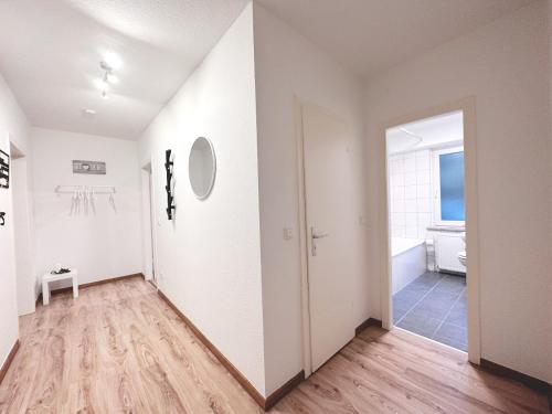 een hal met witte muren en een houten vloer bij # VAZ Apartments RS05 TV, WLAN, Küche, Zentrumsnah in Remscheid