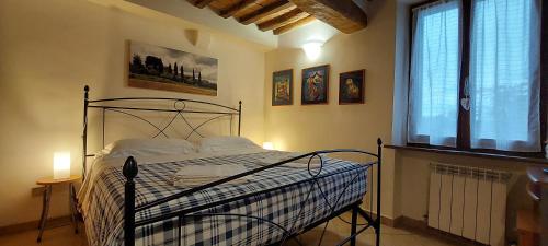1 dormitorio con cama y ventana en COR MAGIS KAMULLIA - 200 meters from the historic center and close to the train station en Siena