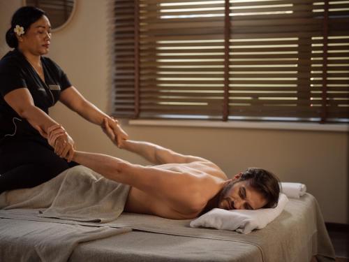 a woman giving a man a leg massage on a bed at Arka Medical Spa in Kołobrzeg