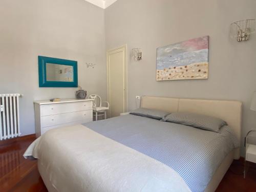 - une chambre avec un lit, une commode et un tableau dans l'établissement La Porte de France by Connexion, à Menton