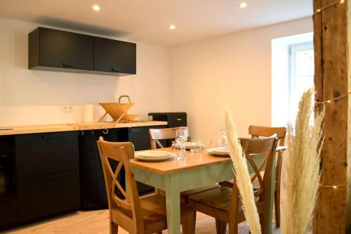 une cuisine et une salle à manger avec une table et des chaises dans l'établissement La Douce Escale, à Turckheim
