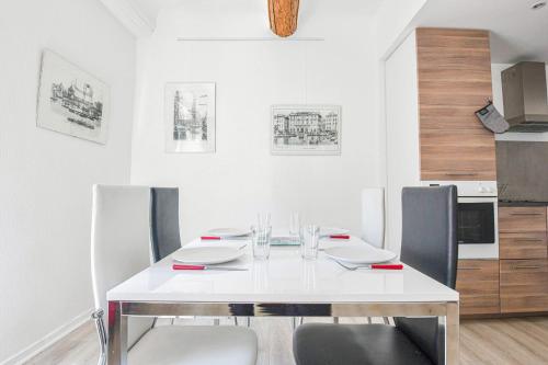 une salle à manger avec une table et des chaises blanches dans l'établissement Appart 2 ch AC proche Cours Julien & Vieux-Port, à Marseille
