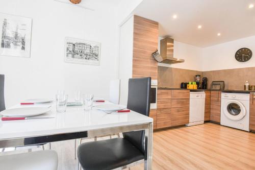- une cuisine avec une table et des chaises blanches dans la chambre dans l'établissement Appart 2 ch AC proche Cours Julien & Vieux-Port, à Marseille
