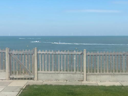 KentにあるBRiSYL BEACH HOUSE, with amazing changing views!の海を背景にした木塀