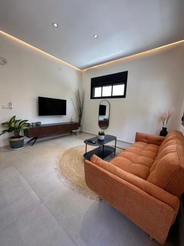 a living room with a couch and a flat screen tv at Prime location apartment in TLV in Tel Aviv