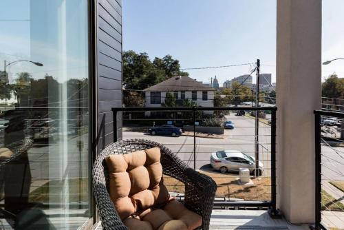 a wicker chair on a balcony with a view of a parking lot at Capitol View Condos by One Fine Bnb - Paramount in Austin