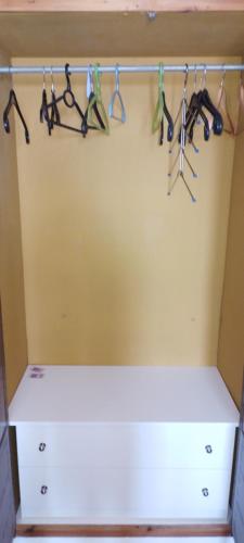 a closet with a white shelf and hangers at Loggia in Agia Galini