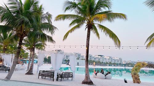 um resort com palmeiras e uma piscina em Siro House- Homestay cao cấp Vinhomes Ocean Park, Gia Lâm em Hanói