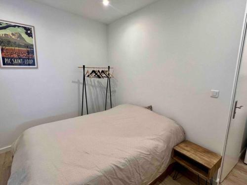 une petite chambre avec un lit et une table dans l'établissement Montpellier centre - La Fenêtre de l’écusson, à Montpellier