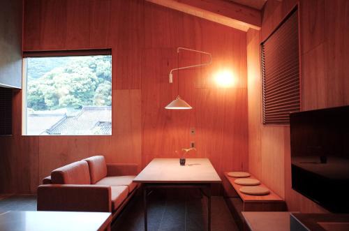 洲本市にあるMAGATAMA.INNのソファ、テーブル、窓が備わる客室です。