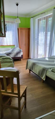 sypialnia z 2 łóżkami i krzesłem w obiekcie Kwatery Prywatne Beata w mieście Darłowo