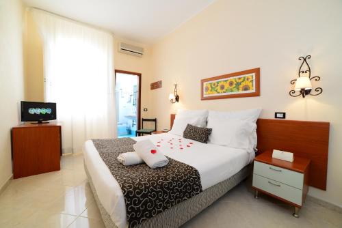 a bedroom with a large bed and a television at Mira Spiaggia in San Vito lo Capo