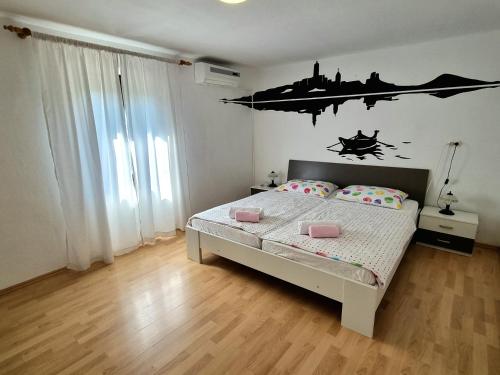 a bedroom with a bed with a poster on the wall at Apartment Deni in Skrbčići