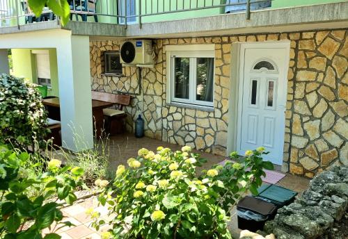 Casa de piedra con puerta blanca y teclado en Apartment Deni, en Skrbčići