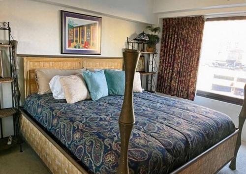 a bedroom with a large bed with blue and white pillows at ON THE STRIP - Classic Comfort - 2 Bedroom Condo in Las Vegas