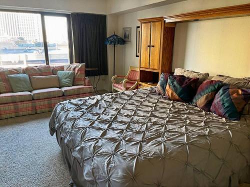 a bedroom with a large bed and a couch at ON THE STRIP - Classic Comfort - 2 Bedroom Condo in Las Vegas