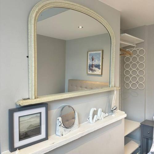 einen Spiegel auf einem Regal mit einem TV in einem Zimmer in der Unterkunft Cosy Central flat in the heart of Brighton in Brighton & Hove