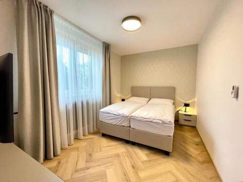 a bedroom with a bed and a large window at Villa Bea in Bratislava