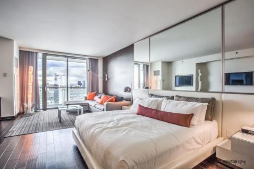 a bedroom with a large bed and a living room at Strip View - Luxurious Studio at Palms Place in Las Vegas