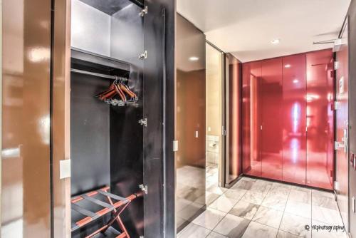 a walk in closet with red walls and a glass door at Strip View - Luxurious Studio at Palms Place in Las Vegas