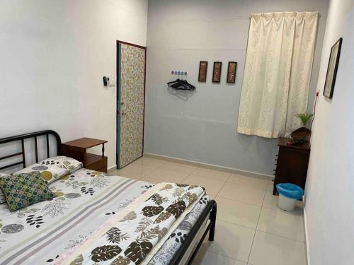 a bedroom with a bed in a room with a window at Nest Inn Homestay燕窝家民宿 in Nibung Tebal