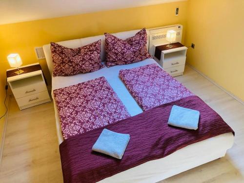 バラトンサールソーにあるTóparti Apartmanházのベッドルーム1室(紫色のシーツと枕が備わる大型ベッド1台付)