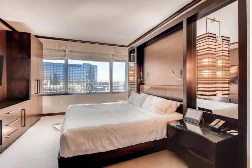a bedroom with a bed and a desk and a window at Perfect - Lux 1BR Suite at Vdara in Las Vegas