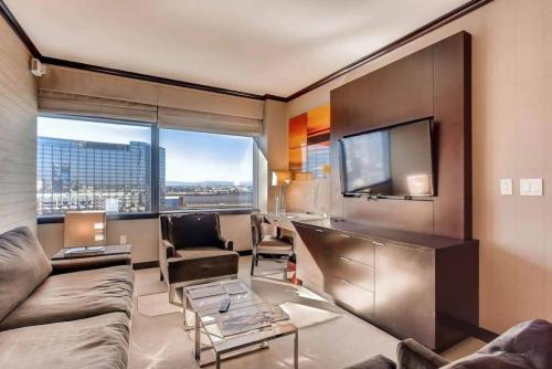 a living room with a couch and a tv at Perfect - Lux 1BR Suite at Vdara in Las Vegas