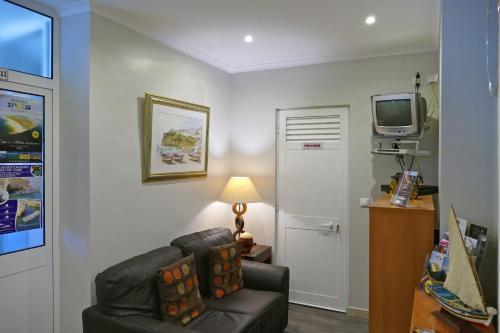 a living room with a couch and a tv at Guest House Sao Filipe in Faro
