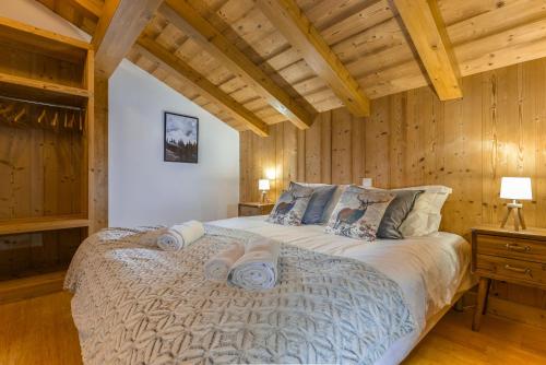 une chambre avec un grand lit dans une pièce aux murs en bois dans l'établissement Chalet Chardonnet, à Chamonix-Mont-Blanc