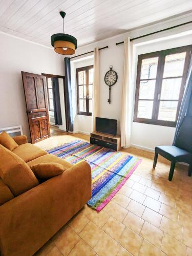 uma sala de estar com um sofá e uma cadeira em Appartement Saint Jean 2 Cosy et Confort em Villefranche-de-Conflent