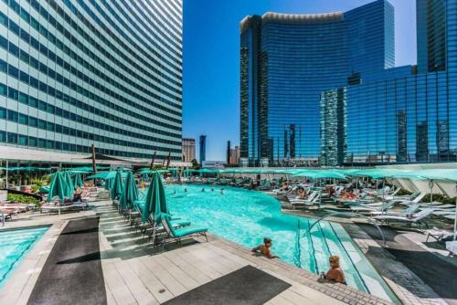 a pool with chairs and people in a city at Perfect - Lux 1BR Suite at Vdara in Las Vegas