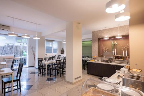 cocina y comedor con mesas y sillas en Hotel Akropol, en Paralia Katerinis